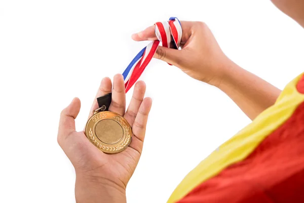 Atleta segurando medalha de ouro com fita na mão — Fotografia de Stock