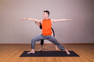 Yoga eğitmeni düzeltme öğrenci Warrior 2 veya Virab gerçekleştirme