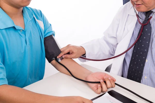 亚洲医生从病人手臂血压测量 — 图库照片