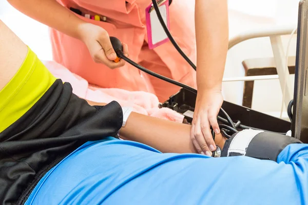 Zbliżenie pielęgniarka przyjmuje pacjentów ciśnienie krwi — Zdjęcie stockowe