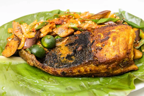 Close-up dari ikan pari panggang populer dengan rempah-rempah dan sayuran disajikan di daun pisang — Stok Foto