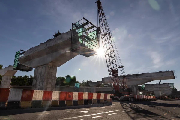 Silhouet met ochtendzonnestralen op de brug over de snelweg infrastructuur in aanbouw — Stockfoto