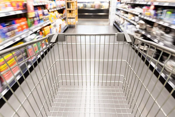 Carro de carrito de compras que se mueve en el supermercado con fondo de pasillo borroso movimiento —  Fotos de Stock