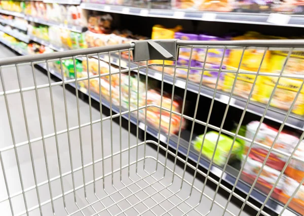 Carro de carrito de compras que se mueve en el supermercado con fondo de pasillo borroso movimiento —  Fotos de Stock