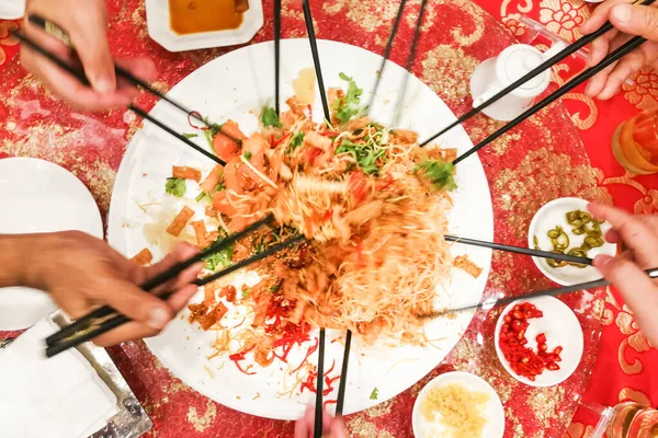 Gerak kabur orang-orang melemparkan yusheng atau yee bernyanyi, hidangan selama Tahun Baru Cina untuk keberuntungan dan kemakmuran — Stok Foto