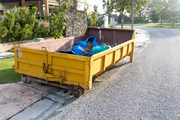 Lixo roro lixeira recolhe lixo no local de construção — Fotografia de Stock