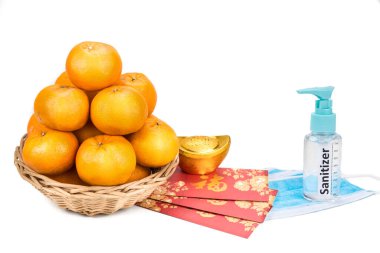 Çin yeni yılı. Mandalina portakalları, kırmızı zarf ve korunmak için yüz maskesi dezenfektanı. Çince kelime İngilizcede refah olarak tercüme edilir.