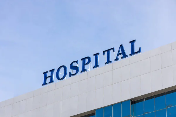 Primer plano de la fachada del edificio con señalización de palabra del hospital — Foto de Stock