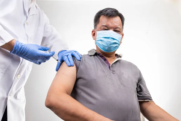 Asian middle age man receiving Covid-19 vaccine injection onto the arm — Stock Photo, Image