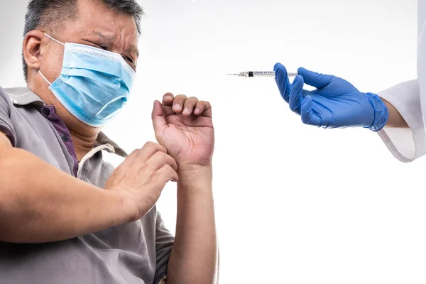 Fearful worried middle age man reacting to medical practitioner holding syringe loaded with Covid-19 vaccine — Stock Photo, Image