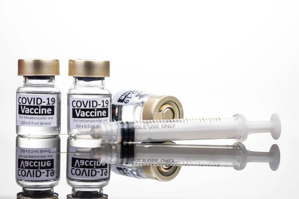 Botol vaksin Covid-19 dengan konsep jarum suntik pada permukaan reflektif — Stok Foto