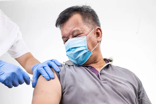 Close-up of Asian middle age man receiving Covid-19 vaccine injection onto the arm — Stock Photo, Image