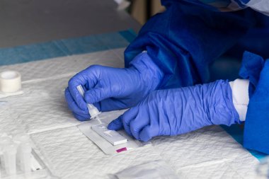 Seri sağlık çalışanları test kiti üzerinde covid-19 numune kültürünü test etmeye hazırlanıyor.