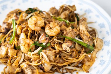 Penang char kuey teow 'a yakın çekim Malezya' nın siyah soslu karides ve yumurtalı kızarmış eriştedir.