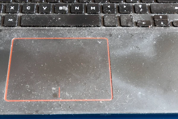 在肮脏和不卫生的笔记本电脑上的特写鼠标垫和键盘，里面全是灰尘和微粒 — 图库照片