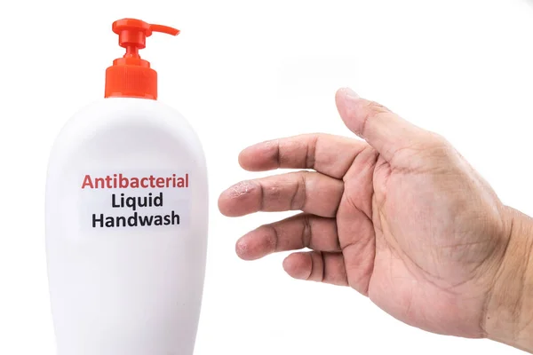 Сухая кожа на пальце с бутылкой антибактериальной жидкости для мытья рук. Частое мытье рук вызывает сухость кожи — стоковое фото