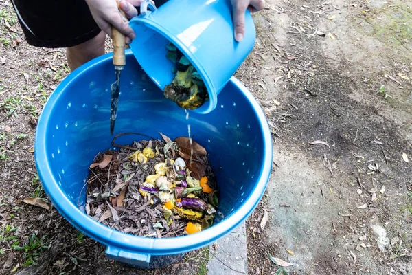 Osoba přidávající kuchyňský organický zelený odpad do koše, která má být přeměněna na kompost hnojivo — Stock fotografie