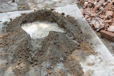 Çimento ve kum, inşaat için havana dönüştürülecek suyla karıştırılır.