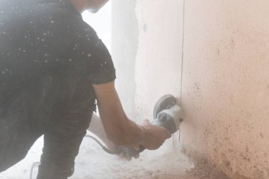 Disk kesme aracı ile beton duvar kesen işçiler, etrafında alacakaranlık parçacıkları yanar