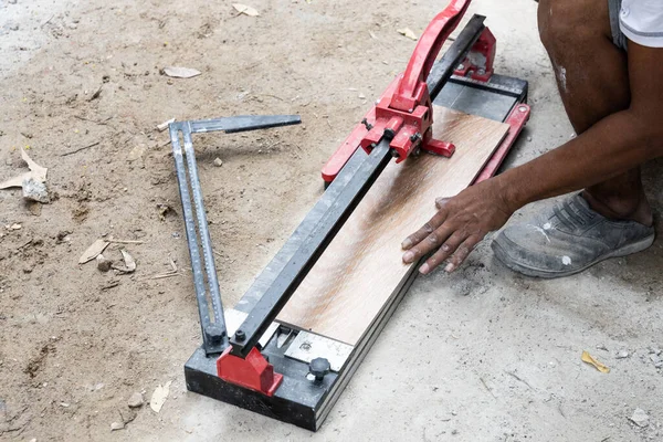 Arbetare skära keramiska plattor med kakel skärverktyg — Stockfoto