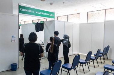 KUALA LUMPUR, MALAYSIA, 16 Temmuz 2021: WTC 'deki Malezya Ulusal Aşılama Programı' ndaki Covid-19 Aşılama alanına gitmek için sıralarının gelmesini bekleyen insanlar