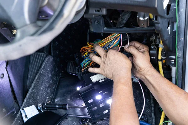 Автотехник диагностирует и устраняет проблемы с проводкой автомобиля — стоковое фото