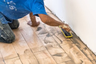 İşçi yeni seramik fayanslara harç uyguluyor. Hareket bulanıklığı amaçlandı.