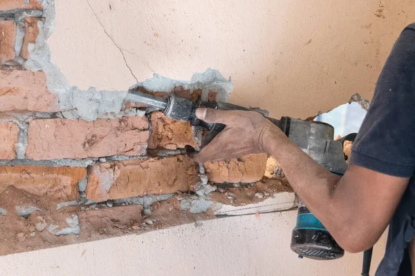 Arbeiter brechen mit einem Abrisshammer die Wandoberfläche auf. Bewegungsunschärfe beabsichtigt. — Stockfoto