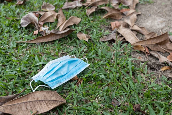 Litter of used surgical face mask with high usage due to covid pandemic polutes the environment — Stock Photo, Image