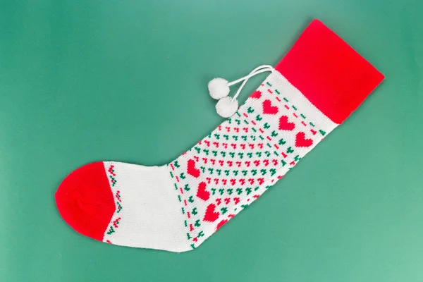 Christmas socks with heart shaped stitches in green background. — Stock Photo, Image