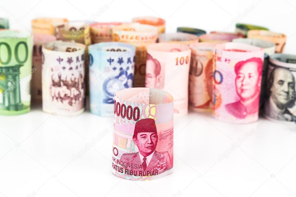 Pile of rolled-up currency notes with Indonesia Rupiah in front