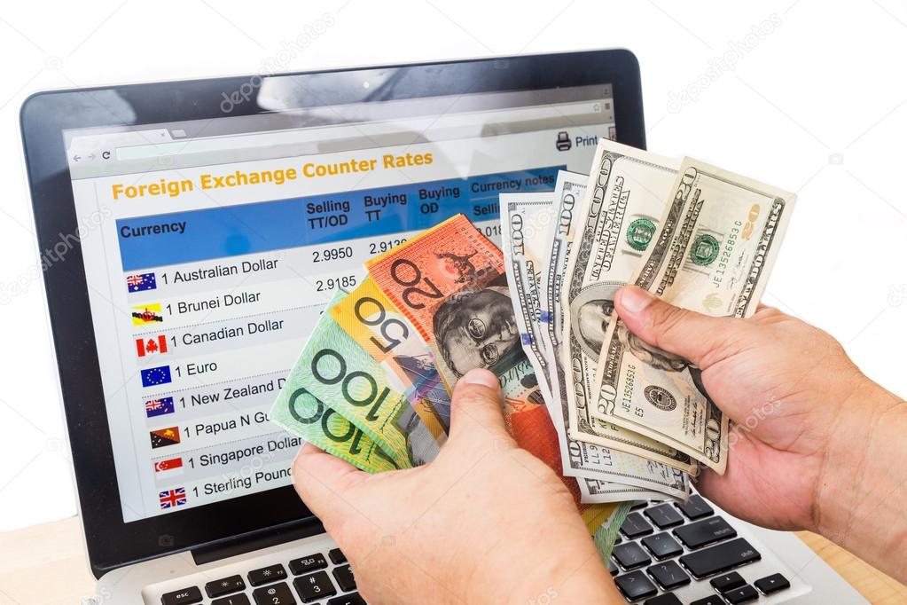 Hand sorting USD and Australian Dollar in of currency exchange chart on computer screen. Stock Photo by ©Thamkc 85981868