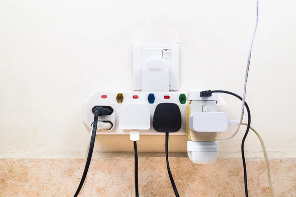 Varios enchufes de electricidad conectados al adaptador de multi es dangerou —  Fotos de Stock