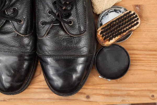 Esmalte de zapatos con pincel, paño y botas desgastadas en plataforma de madera — Foto de Stock