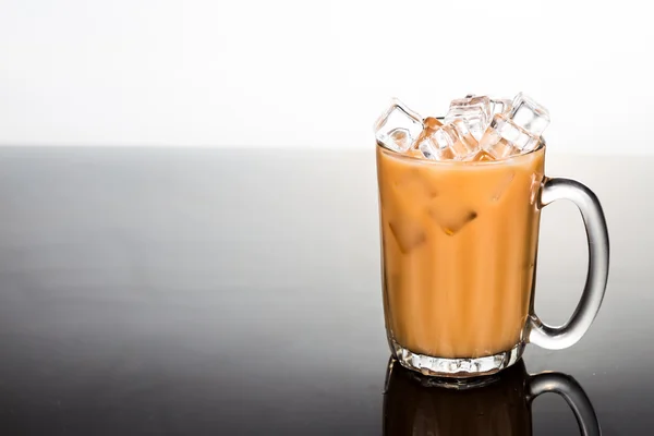 Erfrischenden eiskalten Kaffee mit Milch in transparentem Glas gespült rechts mit zweifarbigem Hintergrund — Stockfoto