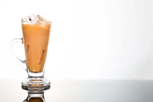 Refreshing ice cold tea with milk in transparent glass flushed left — Stock Photo, Image