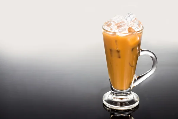 Café gelado refrescante com leite em vidro transparente na superfície reflexiva — Fotografia de Stock