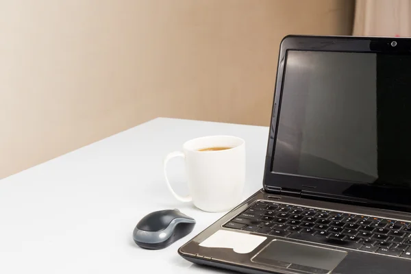 笔记本计算机和咖啡杯子着没人的桌子上 — 图库照片