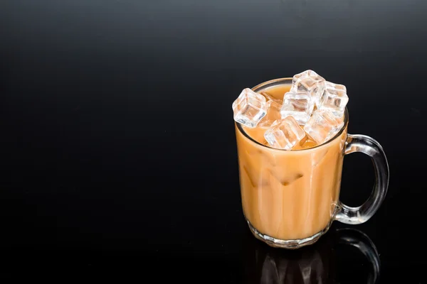 Refrescante té frío de hielo con leche en vidrio transparente sobre fondo oscuro — Foto de Stock