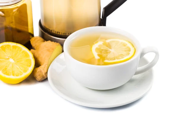 Stimulating hot ginger and lemon tea in a cup and filter jar — Stock Photo, Image