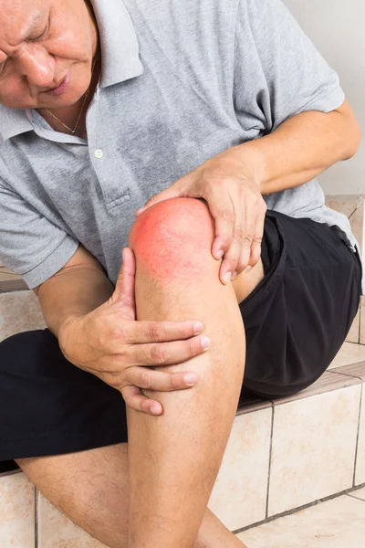 Reifer Mann mit schmerzhaftem Kniegelenk sitzt auf Stufen — Stockfoto