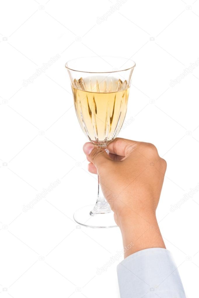 Hand holding crystal wine glass with white wine while ready to toast and cheers