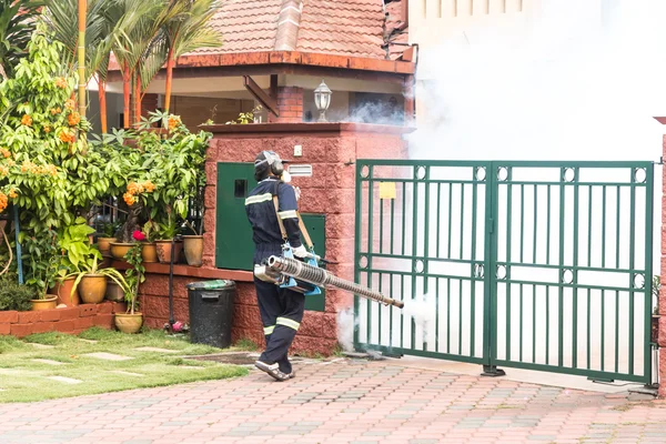 Trabajador empañando zona residencial con insecticidas para matar aedes mosquitos —  Fotos de Stock