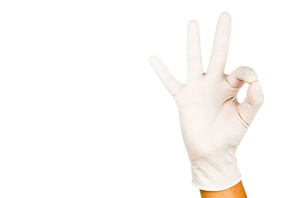 Mão no gesto de luva de látex cirúrgico Ok contra backgrou branco — Fotografia de Stock