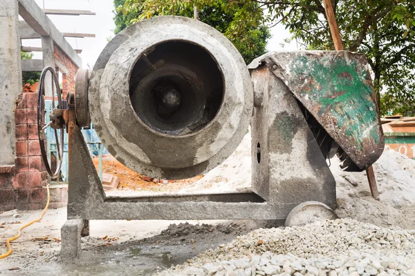 Cement concrete mixer with construction site in background — Stock Photo, Image