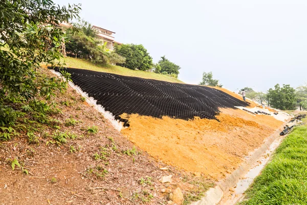 Slope erosion control with grids and earth on steep slope — Stock Photo, Image