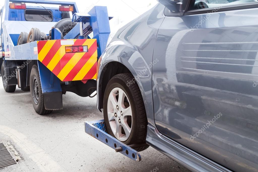 Tow truck towing a broken down car on the street Stock Photo by ©Thamkc