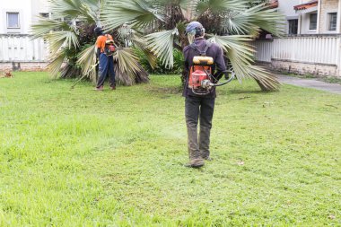 İşçi ile koruyucu giysi kesme çim çim kesici ile
