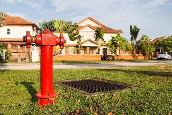 Красный пожарный гидрант в стратегическом жилом комплексе готов к чрезвычайной ситуации — стоковое фото