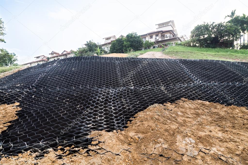 Slope erosion control with grids and earth on steep slope.